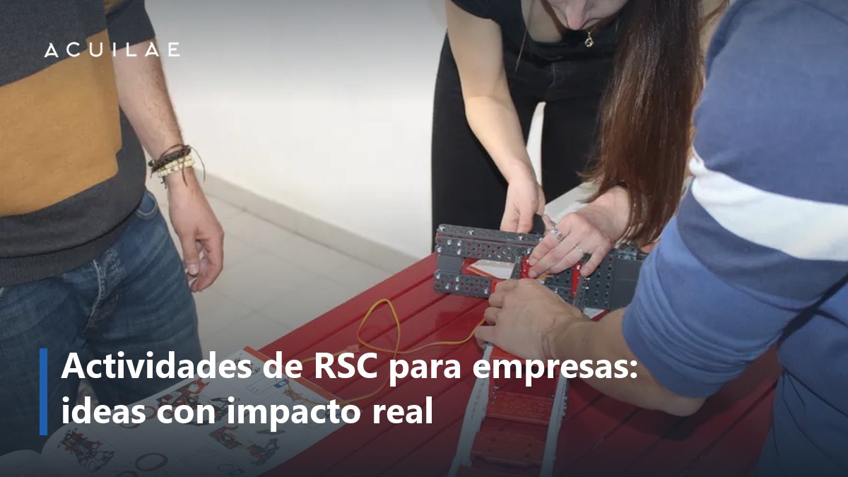 Actividades de RSC para empresas: dos compañeros construyendo un robot sobre una mesa roja en el RSC innovador