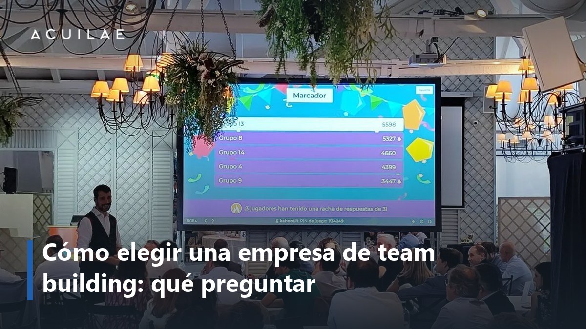 Cómo elegir empresa de team building: salón de un evento de empresa con el presentador del quiz y el marcador en pantalla