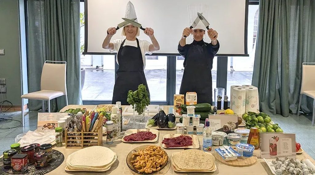 Cómo elegir empresa de team building: participantes cocinando con los ingredientes sobre la mesa en un MasterChef para empresas