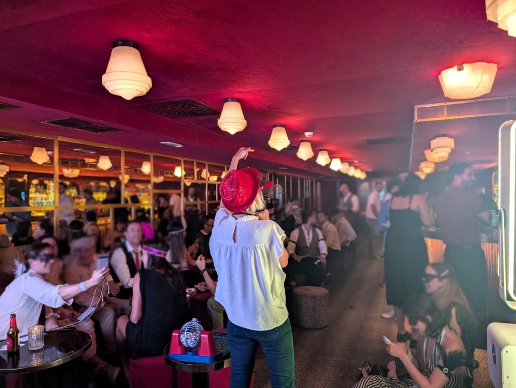 Cómo elegir empresa de team building: sala llena de empresa jugando todos a la vez a un bingo con presentadora