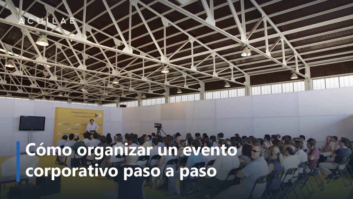 Cómo organizar un evento corporativo: asistentes sentados en el espacio de un evento corporativo antes de empezar el programa