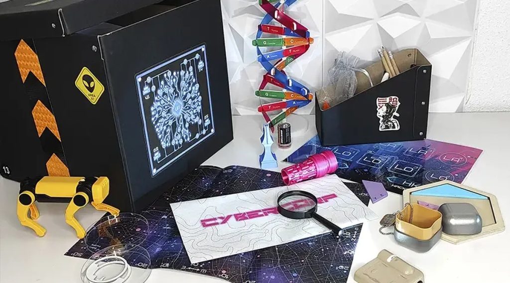 Escape room para empresas: kit de enigmas de Tech in a Box con la caja, las tarjetas y la lupa sobre la mesa