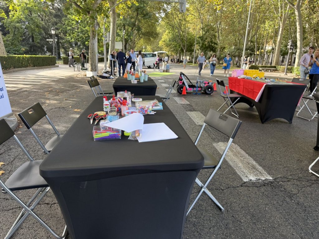 Family day para empresas: mesas de talleres preparadas al aire libre por zonas en un family day de empresa
