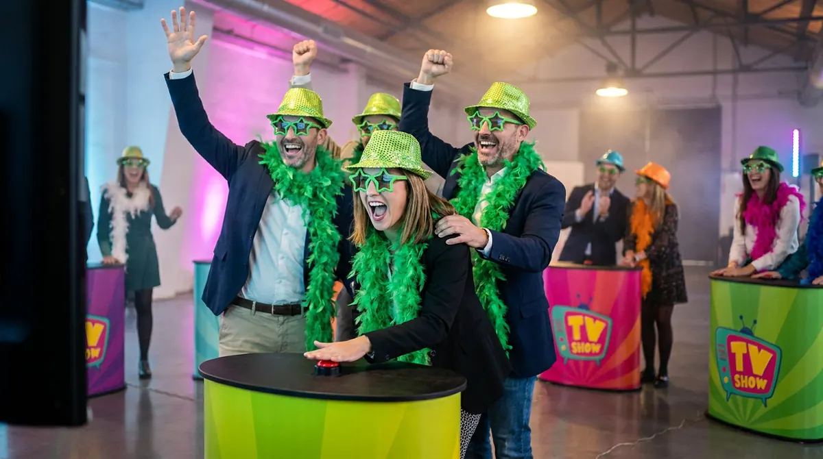 Compañeros caracterizados celebran un punto en el TV show musical para empresas