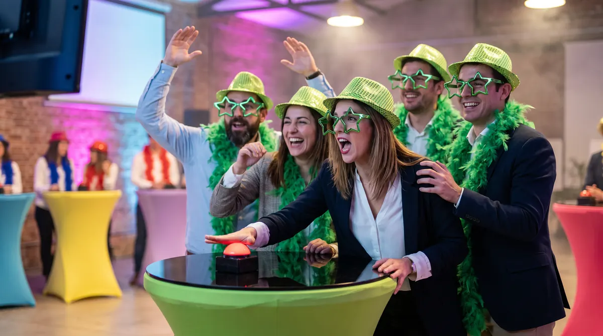Equipo con sombreros y boas verdes pulsando el botón del atril en el concurso musical Furor