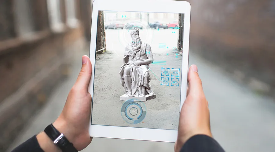Tablet mostrando una escultura en realidad aumentada durante una gymkhana con iPads por la ciudad