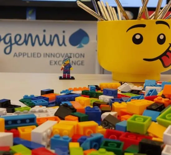 Piezas de Lego de colores y una minifigura sobre la mesa de un taller