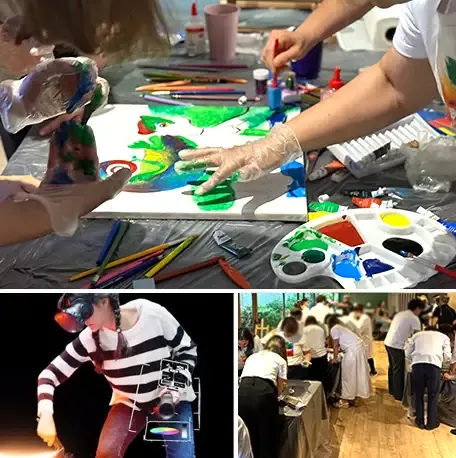 Participantes con guantes pintando juntos un lienzo de colores en una sesión de Team Painting
