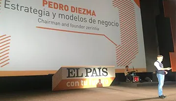 Conferenciante en un gran escenario presentando una charla sobre estrategia y modelos de negocio