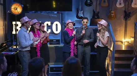 Participantes cantando con sombreros de lentejuelas en el bingo musical