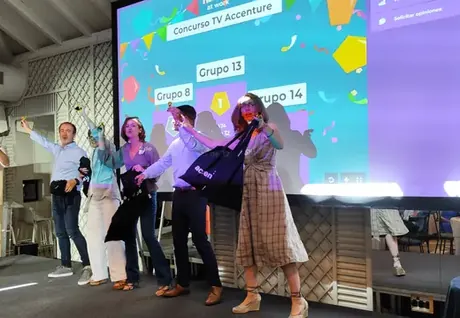 Equipos celebrando en el escenario de un concurso de TV para empresas