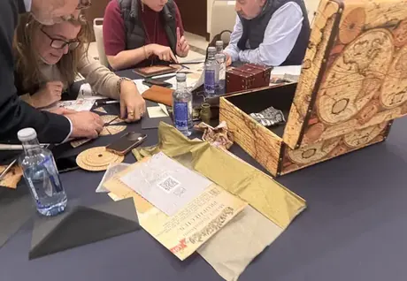 Equipo resolviendo pistas alrededor de un baúl en un escape room