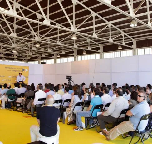 Público asistente a una ponencia en una gran nave durante el evento anual de Cintra