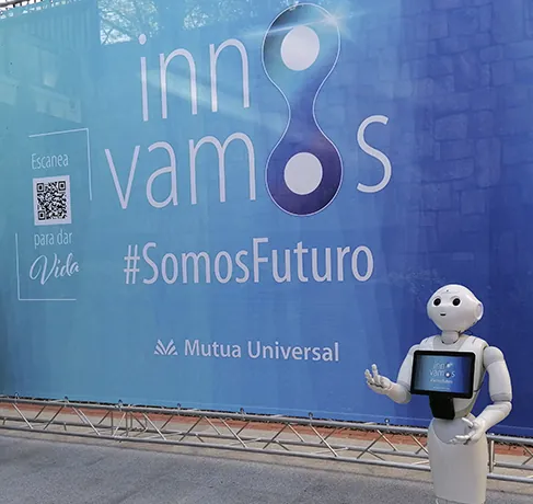 Robot de bienvenida junto a la lona Innovamos de Mutua Universal en su evento corporativo