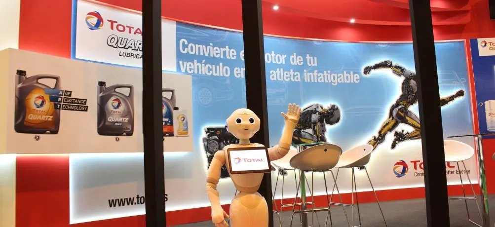 Robot humanoide saludando en el stand de Total en la Feria del Motor de Madrid
