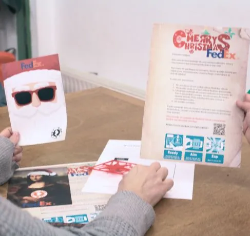 Participantes resolviendo un juego personalizado con tarjetas y carta navideña de marca