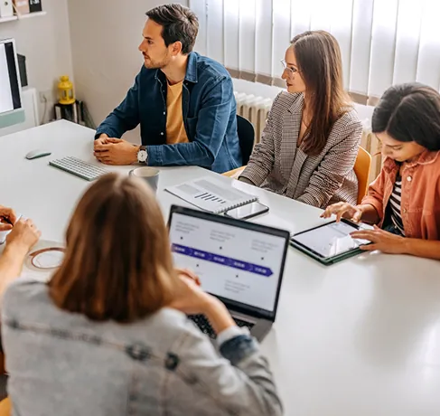 Equipo de trabajo reunido en una oficina con portátil y tableta para el Kit Consulting