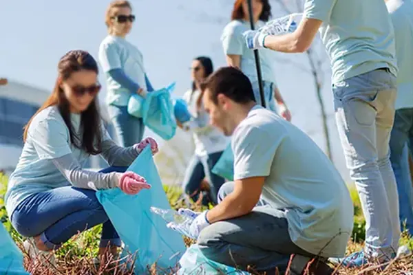 Voluntarios recogiendo residuos en un parque durante una actividad solidaria